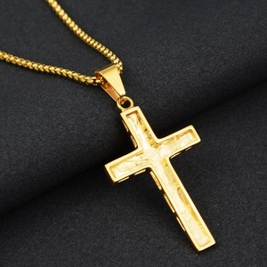 Detailaufnahme von goldenem Kreuzanhänger mit strukturierter Oberfläche und Boxkette