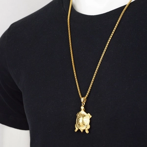Collar con colgante de tortuga dorada estilo hip hop para hombre y mujer sobre fondo negro