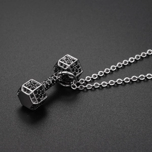 Detailed view of silver dumbbell pendant necklace with micro-paved black zircons