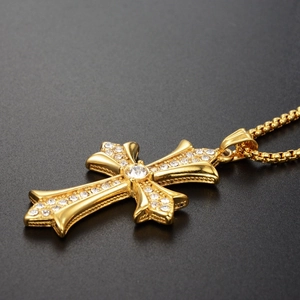 Gros plan du pendentif croix dorée hip hop avec pierres de zircon sur fond gris foncé