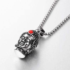 Macro shot of silver Buddha head pendant with red bead inlay on a steel box chain
