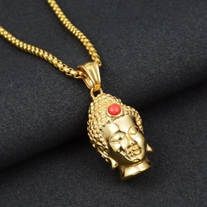 Detailed close-up of a golden Buddha head pendant with red bead inlay and box chain link