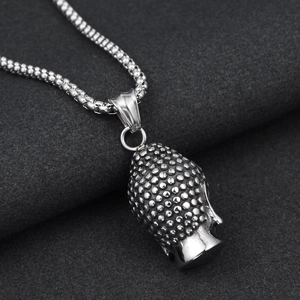 Macro shot of a silver Buddha head pendant in stainless steel with detailed textures