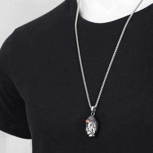 Silver Buddha head necklace for men with red gemstone inlay and box chain on black shirt
