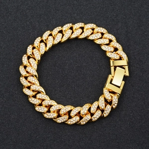 Detail of gold Cuban link bracelet featuring iced out rhinestones and a secure box clasp