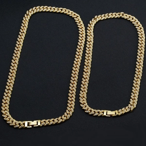 Close-up of golden iced out Cuban link chains with shimmering rhinestones and fold-over clasps