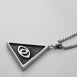 Détail macro du pendentif œil triangulaire argenté hip hop avec bords polis brillants