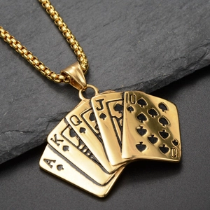 Macro shot of golden royal flush poker pendant with bead chain on black stone