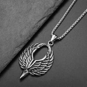 Collier hip hop en acier titane avec pendentif ailes d'aigle sur surface rocheuse