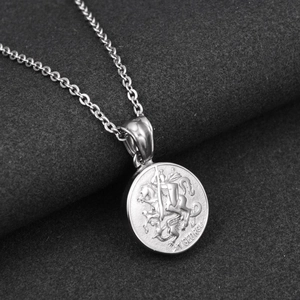 Close-up of Saint George dragon slayer relief on silver round coin pendant necklace