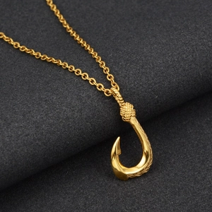 Detailed close-up of golden fish hook pendant with textured rope detail and polished finish