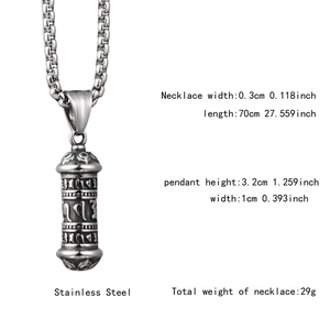 Vue détaillée du pendentif cylindre en acier inoxydable avec motifs sanskrits