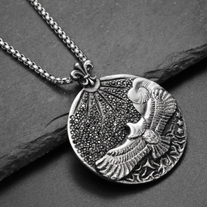 Détail d'un pendentif aigle avec zircons noirs et chaîne robuste en acier titane