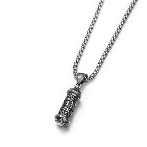 Gros plan d'un pendentif cylindrique en acier titane argenté avec écritures sanskrites