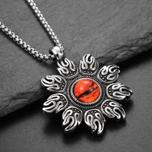 Vue macro d'un collier pendentif flamme punk avec œil rouge sur fond de pierre noire