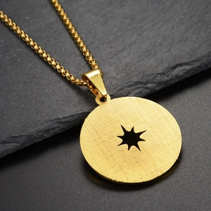 Vue détaillée du collier pendentif étoile dorée hip hop sur une pierre grise texturée
