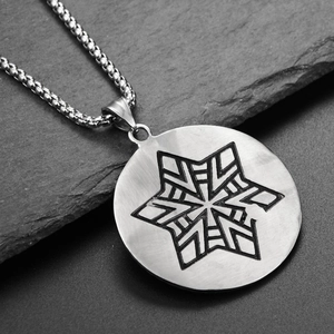 Macro view of stainless steel hexagram star pendant on dark textured stone background