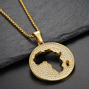 Macro shot of gold-plated African map pendant necklace with white zircons on black stone
