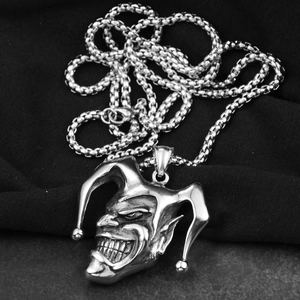 Close-up of vintage silver gothic jester mask pendant with detailed bell hat accents