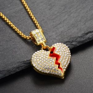 Detail von Hip-Hop Herzanhänger mit Goldbeschichtung, weißen Strasssteinen und rotem Riss