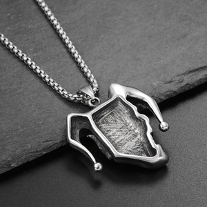 Detail of silver jester pendant with polished edges and dark oxidized texture on beaded chain