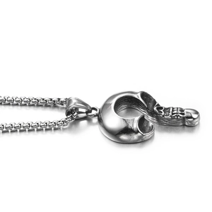 Détail macro du pendentif crochet crâne gothique en acier argenté poli avec chaîne