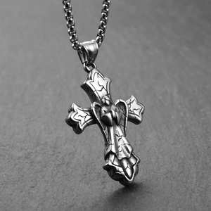 Gros plan du pendentif croix ange en prière gothique avec texture de pierre vintage