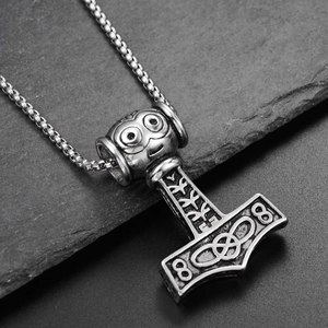 Macro detail of Viking Mjölnir pendant with Nordic runes and vintage oxidized finish