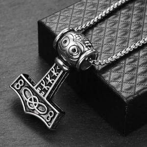 Macro shot of Viking Mjolnir pendant in vintage titanium steel with rune engravings