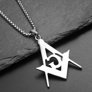 Macro shot of silver Freemason pendant with compass and G logo on bead chain