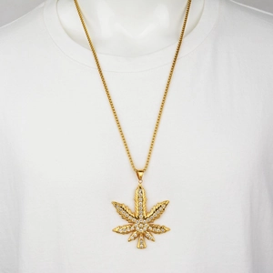 Hip hop gold maple leaf pendant necklace with shimmering crystals on a white t-shirt