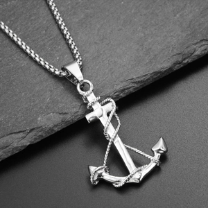 Macro view of a stainless steel anchor pendant with rope details on a stone surface
