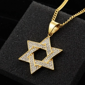 Détail d'un pendentif étoile de David doré avec strass brillants et une fine chaîne à maillons