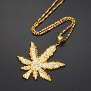 Macro detail of gold hip-hop maple leaf pendant encrusted with sparkling crystals