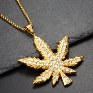 Macro shot of hip-hop gold maple leaf pendant with sparkling rhinestones on box chain