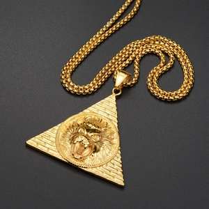 Vue macro détaillée d'un pendentif pyramide doré avec un relief de tête de lion