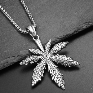 Macro shot of maple leaf pendant in titanium steel with detailed veins on rock background