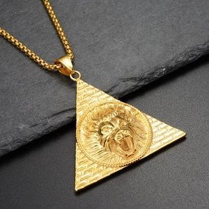 Gros plan du pendentif pyramide à tête de lion dorée sur une chaîne box fond noir