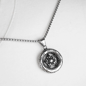 Macro view of silver Roman numeral wheel pendant with star pattern on square chain