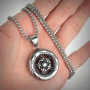 Detailed macro view of silver titanium steel necklace with roman numeral wheel pendant