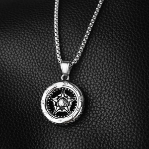 Macro shot of silver metal star pendant with roman numeral outer ring on black leather