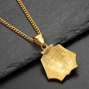 Detail of the brushed texture and sturdy curb chain on the gold pharaoh mask pendant