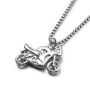 Collier avec pendentif moto en argent poli et chaîne à maille vénitienne sur surface