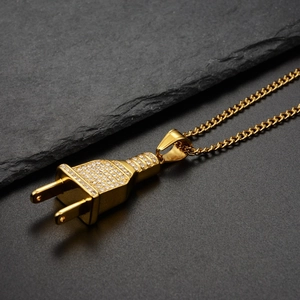 Macro shot of gold-plated hip-hop plug pendant with sparkling zircons on Cuban link chain