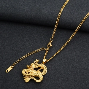 Close-up of gold dragon pendant featuring detailed scales and K14 stamped hallmark