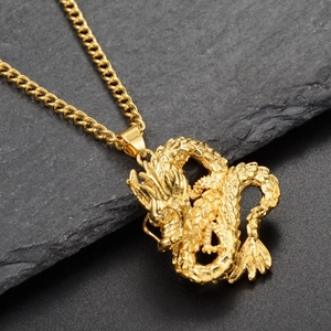 Detailed macro view of a golden Chinese dragon pendant with intricate embossed textures