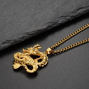Macro shot of detailed golden dragon pendant with clear scales on textured rock
