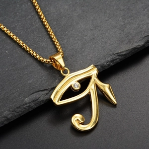 Detailed macro shot of golden Eye of Horus pendant with zircon on grey stone slab