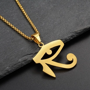 Detailed view of golden Eye of Horus pendant with matte finish on stone surface