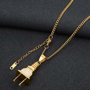 Détail d'un collier pendentif fiche plaqué or avec des strass blancs scintillants